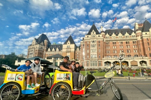Pedicabs in front of a historic building under a cloudy blue sky.